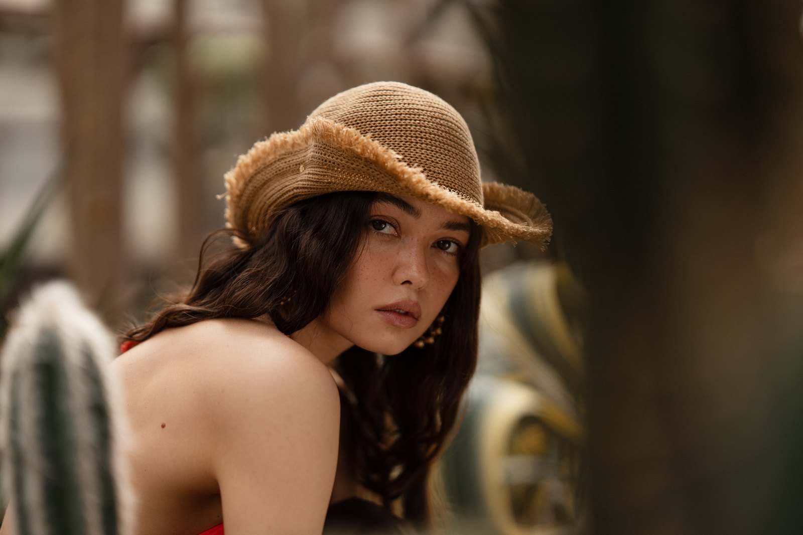 Straw hat portrait among cacti